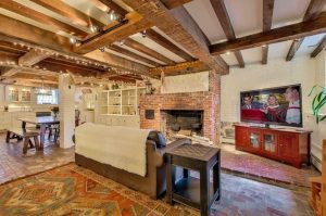 basement kitchen and family room with brick floors and fireplace