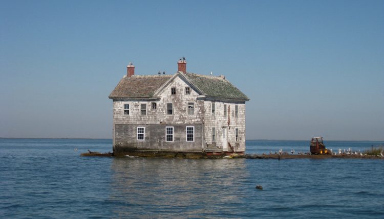 house swallowed by rising sea levels - flood insurance climate change global warming real estate