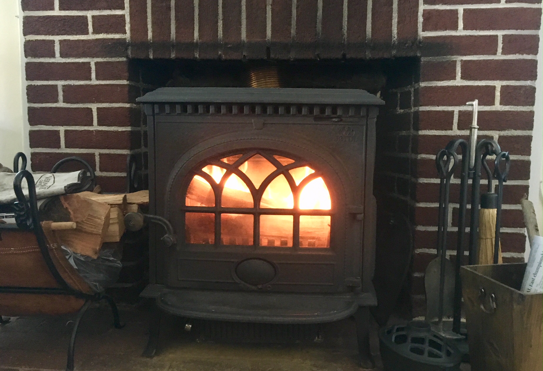 Wood stove in traditional brick fireplace