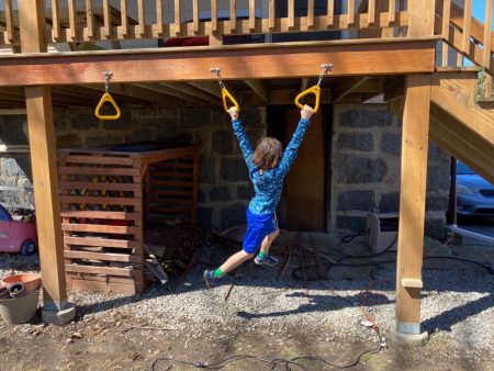 backyard monkey bars installed under deck