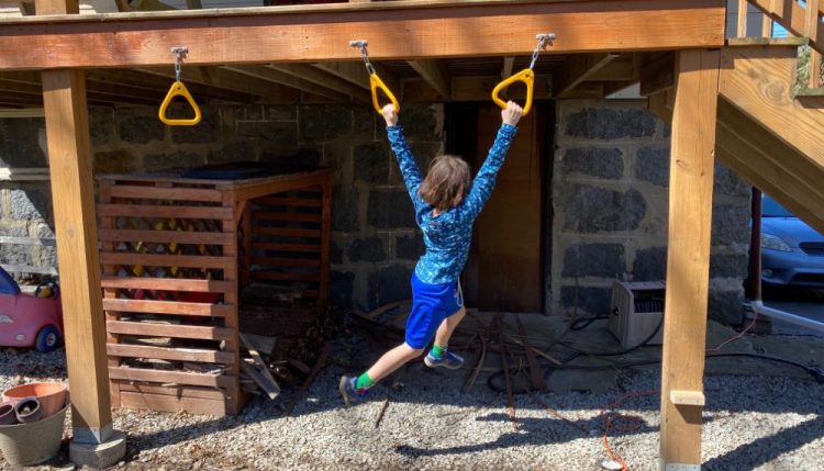 backyard monkey bars installed under deck