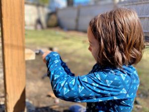 kid using a wrench on the wood block