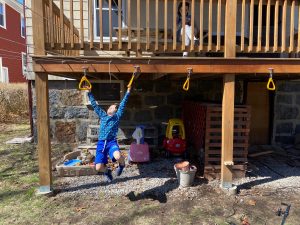 kid swinging on backyard diy monkey rings