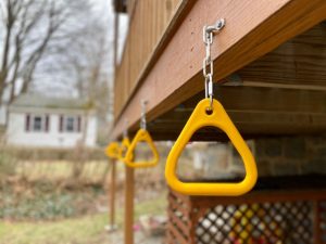 backyard monkey bars installed under deck