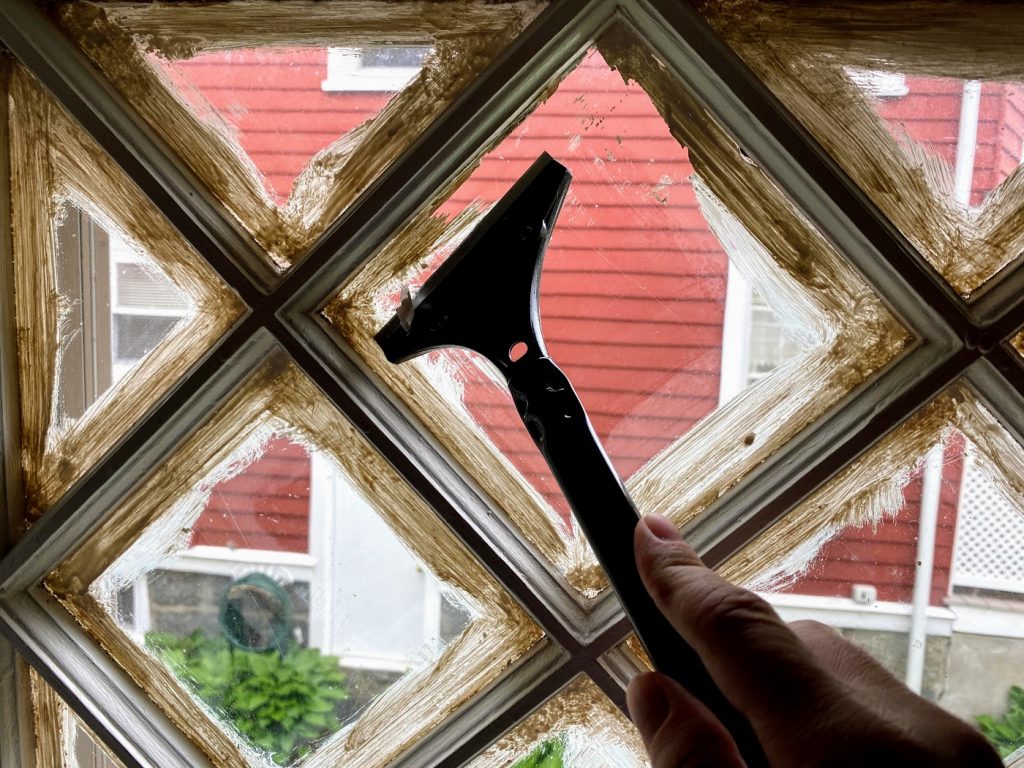 scraping excess paint off window panes