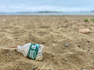 poland spring plastic water bottle on the beach - how to reduce plastic waste