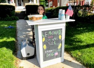 kid selling cookies at diy lemonade stand