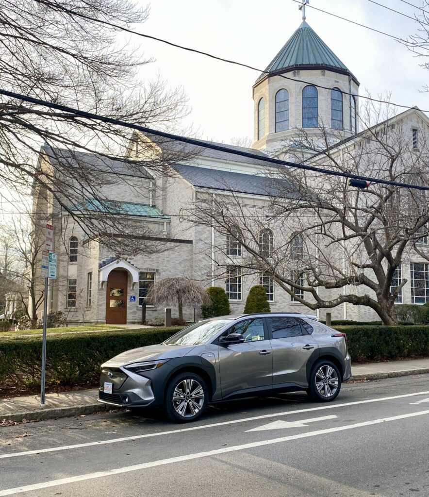 subaru solterra parked in front of a church - real world EV range