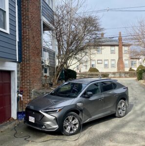 subaru solterra parked and charging in driveway