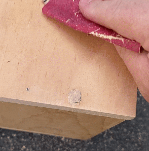 sanding the plugged hole with medium grit sandpaper