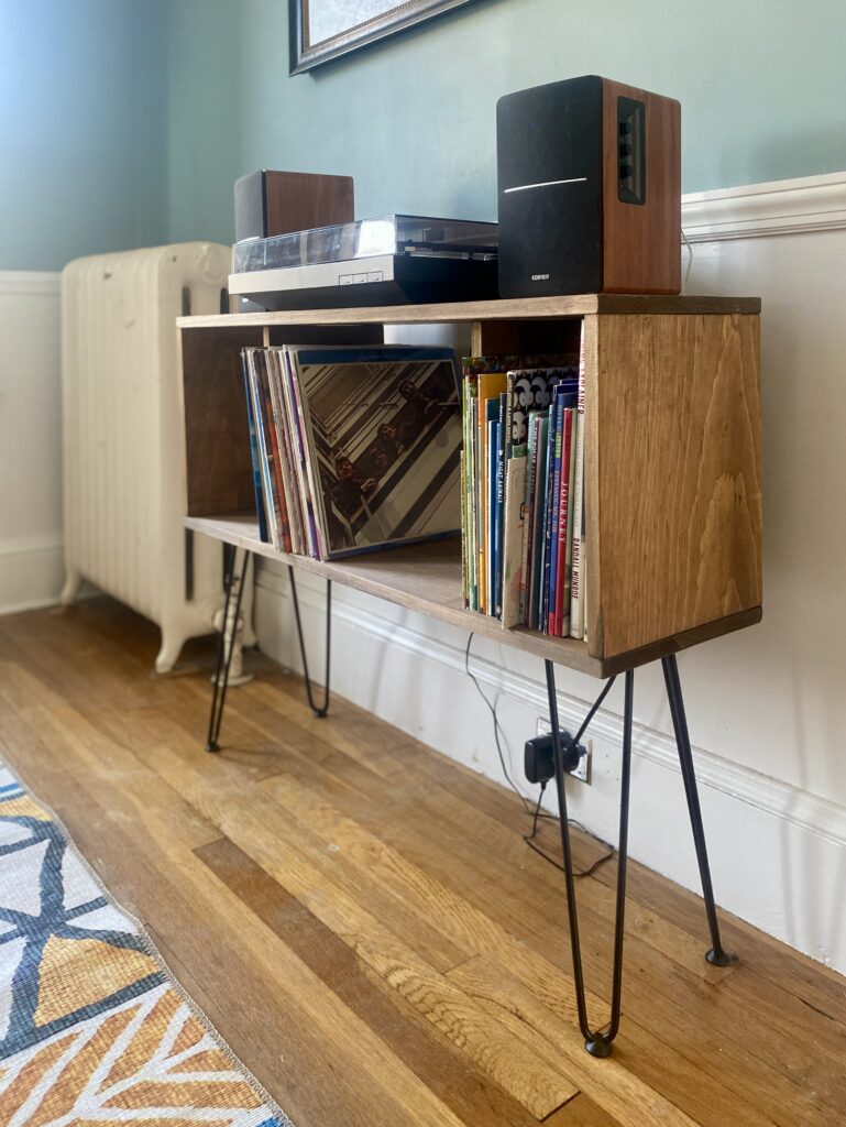 midcentury modern style diy record player stand, with turntable and speakers on top, in a dining room with hardwood floors, colorful carpet
