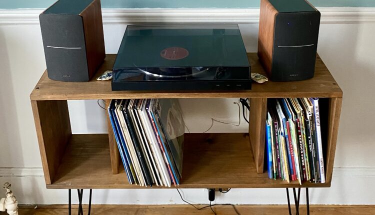 diy midcentury modern record player stand, with turntable and speakers on top and albums in the storage cubbies